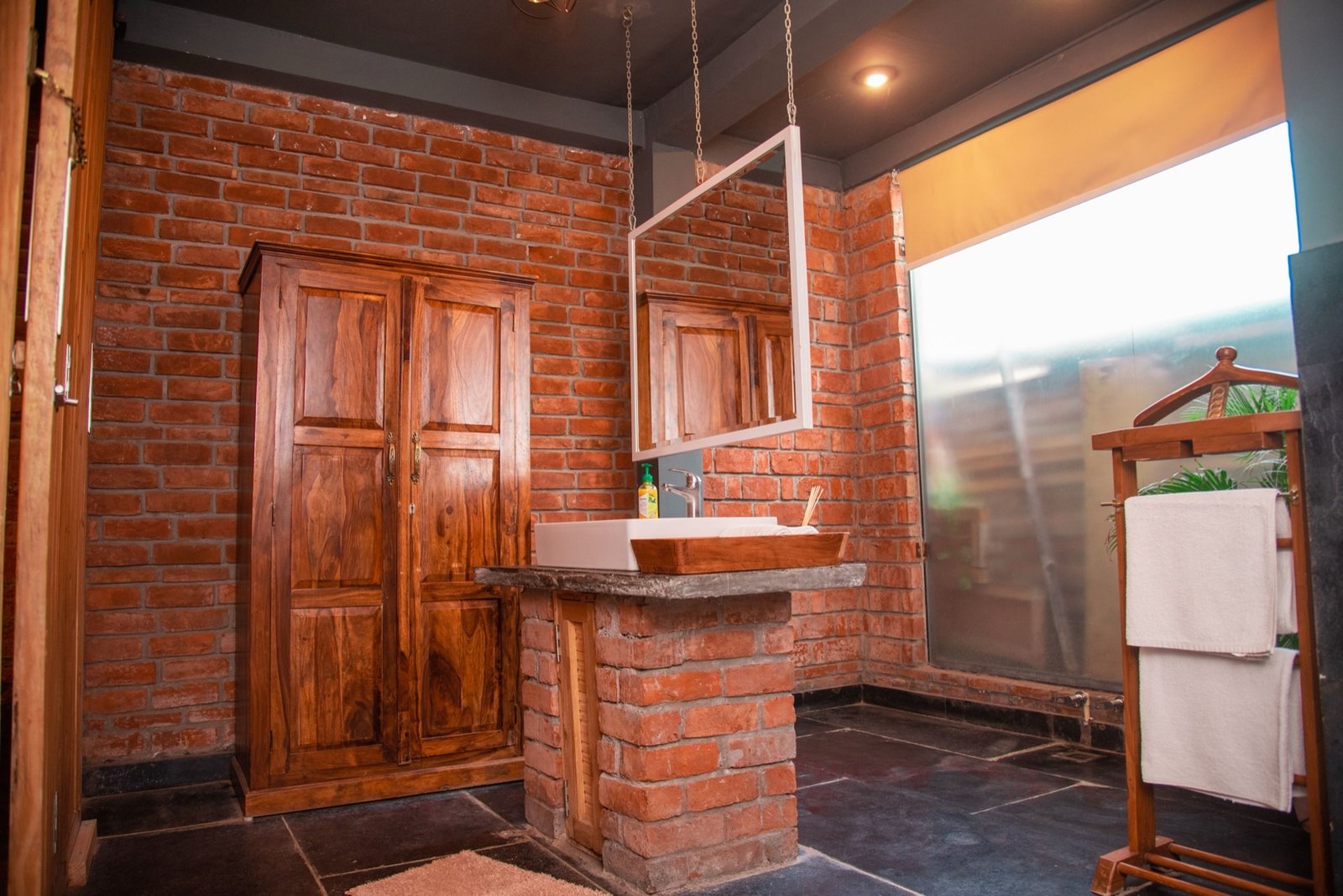 En-suite bathroom with exposed brick and marble — We Woods Farm farmhouse Gurgaon