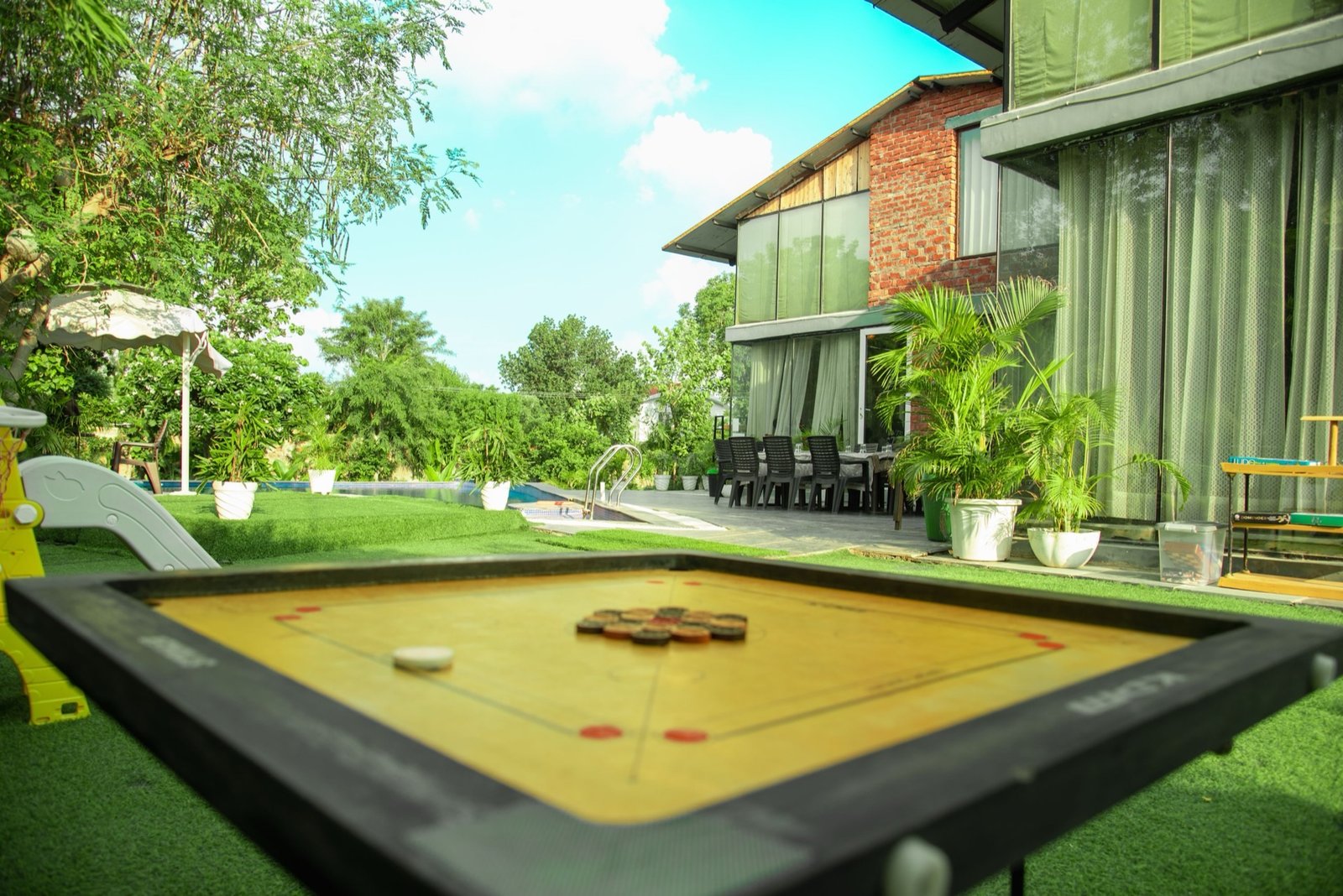 Outdoor carrom board games on the lawn — We Woods Farm farmhouse activities Gurgaon