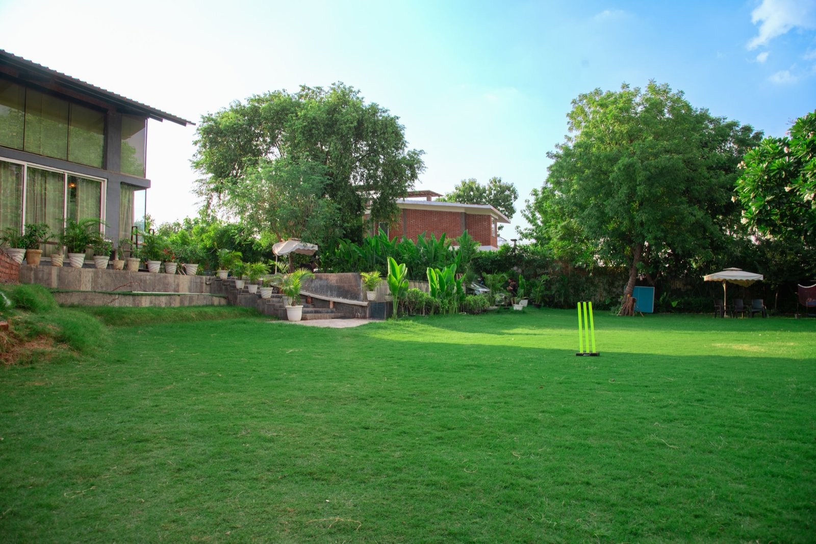 Open cricket ground with lush green lawn — We Woods Farm farmhouse near Gurgaon