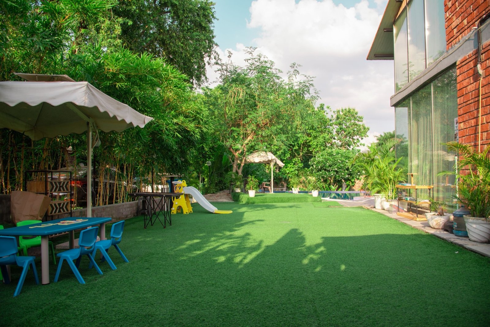 Kids play area with slide and artificial turf — We Woods Farm family farmhouse Gurgaon