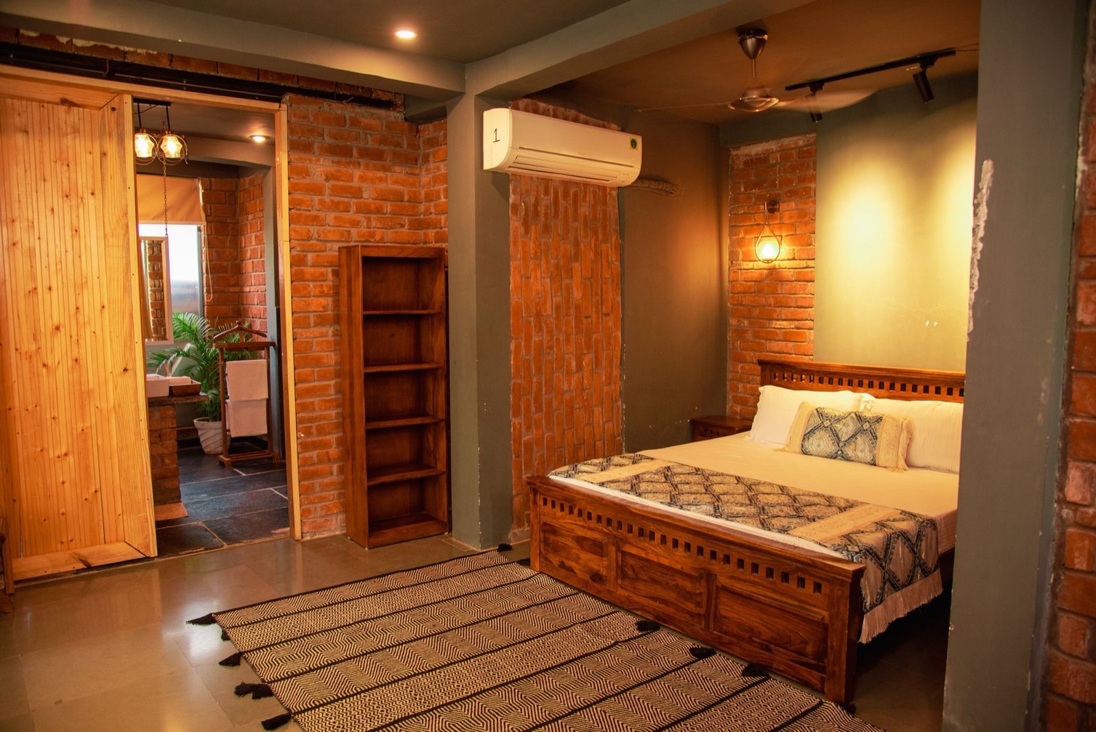 Luxury bedroom Villa A — exposed brick, king bed at We Woods Farm farmhouse Gurgaon