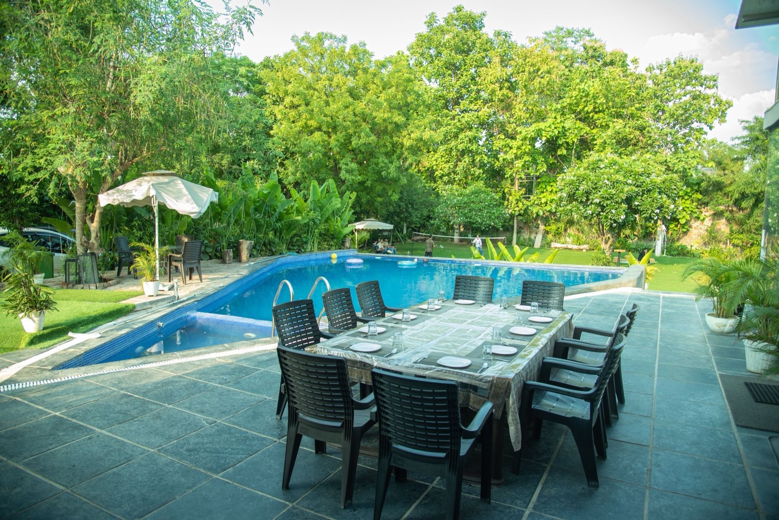 Private pool with outdoor dining table — We Woods Farm farmhouse in Gurgaon