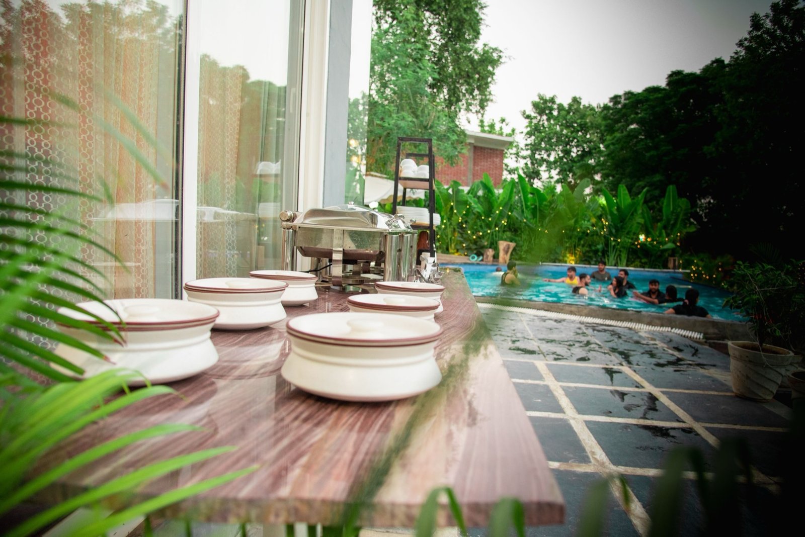 Pool party with buffet dining and guests swimming — We Woods Farm farmhouse Gurgaon